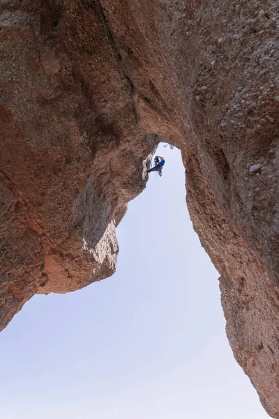 崖の上の人のフリークライマーの垂直ショット — ストック写真