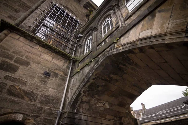 Niski Kąt Ujęcia Łukowego Wejścia Starego Kamiennego Budynku Strzeżonymi Oknami — Zdjęcie stockowe