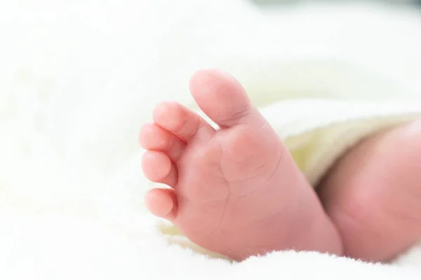 Closeup Foot Newborn Baby Lying Bed Lights — Stock Photo, Image