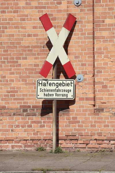 德国砖墙背景上的一个红十字标志 — 图库照片