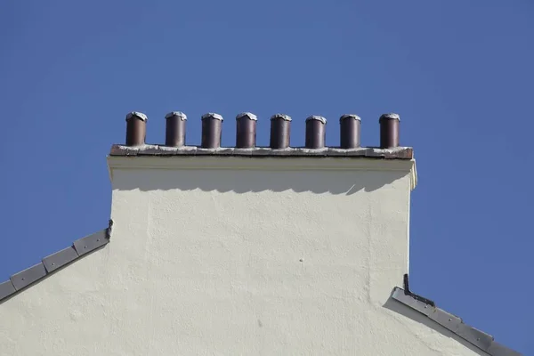 Mavi Gökyüzünün Altında Dairesel Borular Olan Bir Binanın Çatısına — Stok fotoğraf