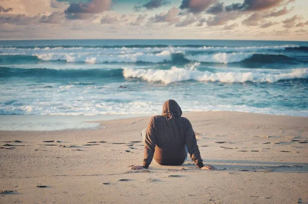 Shallow Focus Shot Male Black Jacket Sitting Sandy Beach — Stock Photo, Image