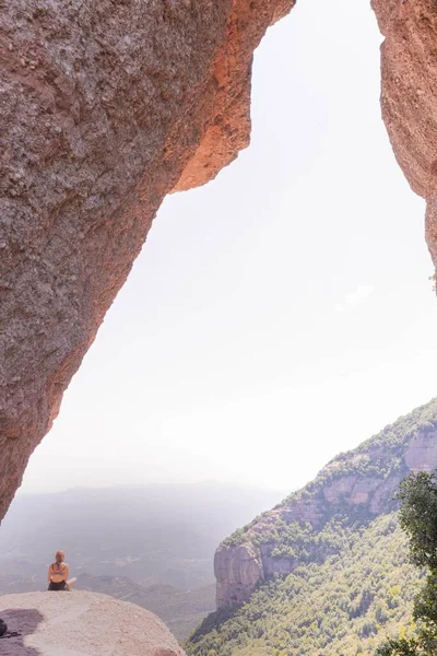 Plano Vertical Una Joven Hembra Sentada Borde Acantilado Piedra Mirando — Foto de Stock