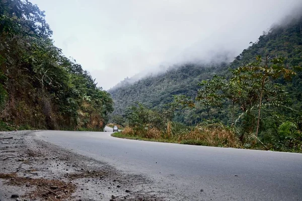 Извилистая Дорога Окруженная Горами Покрытыми Деревьями Облаками — стоковое фото