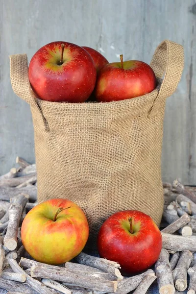 Vertical Closeup Shot Apples Burlap Sack Twigs Front Wooden Background — Stock Photo, Image