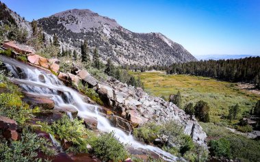 MT ROSE, NEVADA, UNITED STATES - May 30, 2018: Galena Falls, also called the Galena Creek Waterfalls or Tamarack Peak Waterfall, streams down the landscape while the peak of Mount Rose rises behind clipart