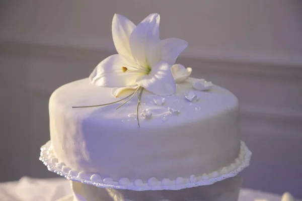 一张带有百合花装饰的漂亮的白色蛋糕的特写照片 — 图库照片