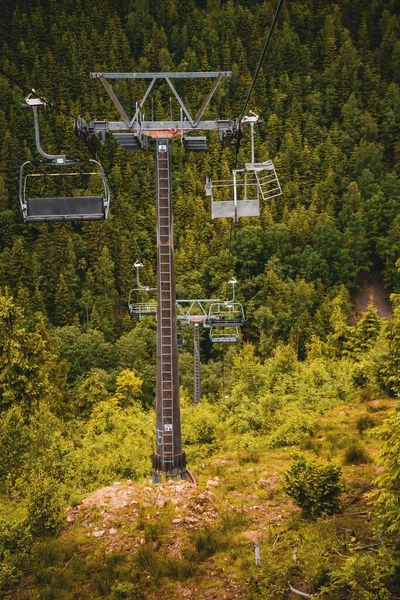 在白天 垂直拍摄的椅子电梯被覆盖着绿色的小山环绕着 — 图库照片