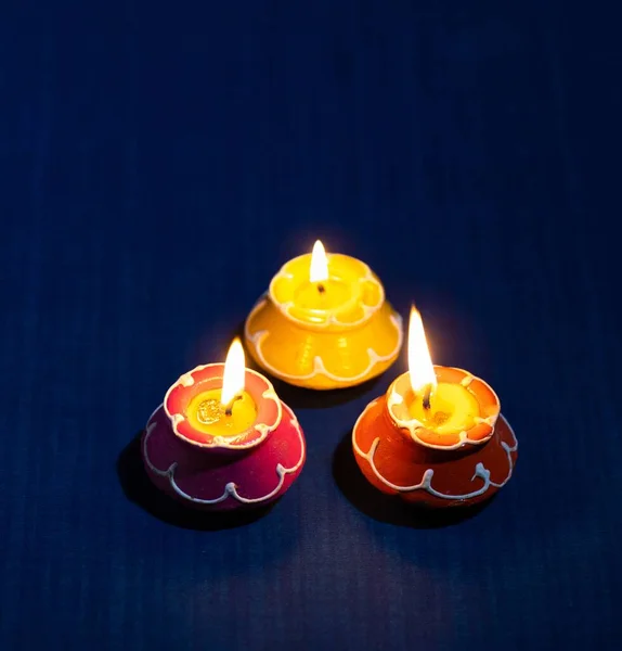 Eine Nahaufnahme Von Drei Schönen Blumenförmigen Brennenden Kerzen Auf Blauem — Stockfoto