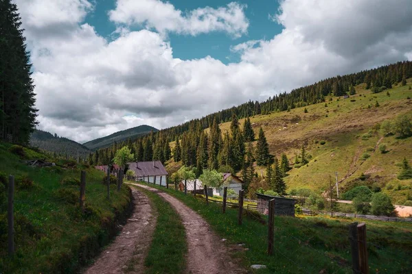 Väg Omgiven Byggnader Och Kullar Täckt Grönska Molnig Himmel Landsbygden — Stockfoto