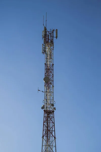 背景の電気通信塔と青い空の垂直ショット — ストック写真
