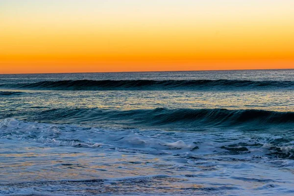 Een Prachtige Foto Van Golven Het Strand Tijdens Zonsondergang — Stockfoto