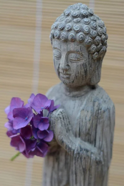 Крупный План Статуи Будды Красивыми Фиолетовыми Лепестками Цветов — стоковое фото