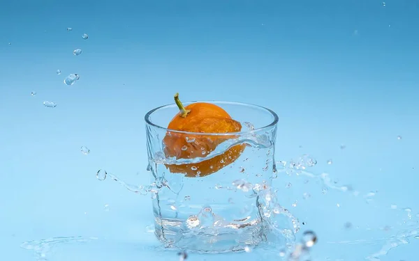Een Close Shot Van Een Sinaasappel Een Glas Water Tegen — Stockfoto