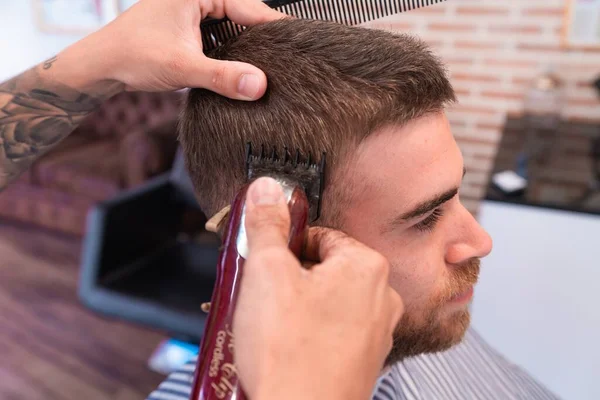 Jeune Coiffeur Coupe Les Cheveux Client Masculin Avec Une Tondeuse — Photo