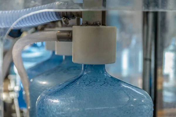 青いペットボトルのチューブできれいな飲料水の生産ライン — ストック写真