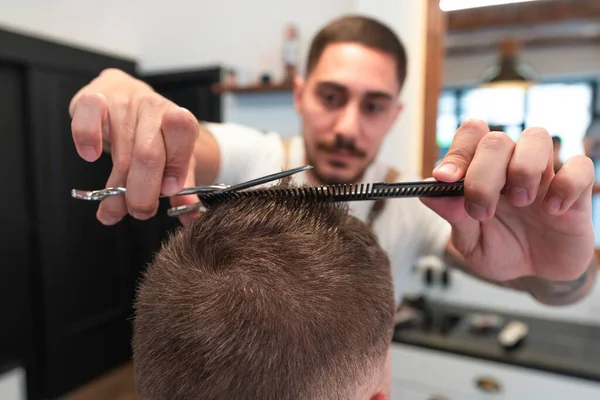 Primer Plano Joven Peluquero Cortando Cabello Cliente Masculino Con Peine —  Fotos de Stock