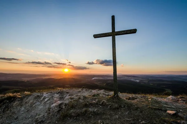 夕日の山の上に大きな十字架の美しいショット — ストック写真
