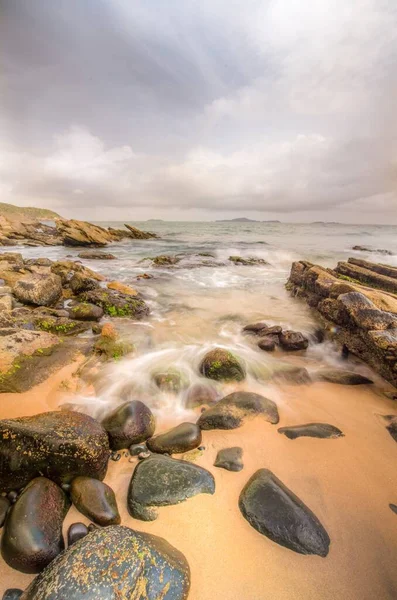 Eine Vertikale Aufnahme Einer Küste Mit Felsen Unter Einem Bewölkten — Stockfoto