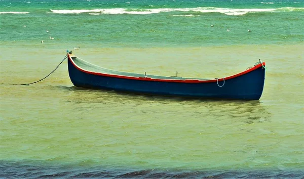 Ένα Μικρό Σκάφος Αγκυροβολημένο Στην Γαλαζοπράσινη Θάλασσα — Φωτογραφία Αρχείου