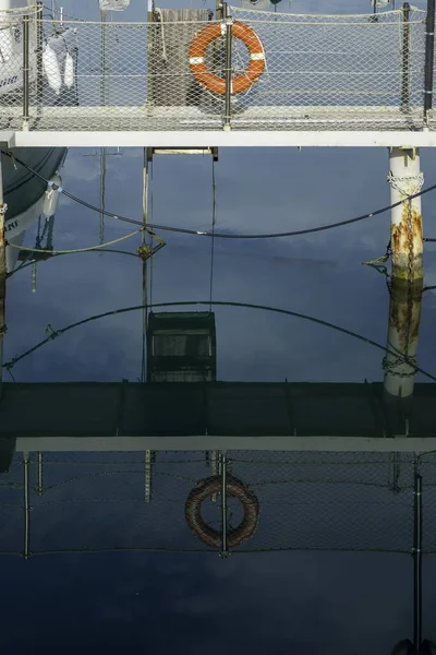 Vertical Shot Pier Lifebuoy Hanging Metal Bar Reflected Seawater — Stock Photo, Image