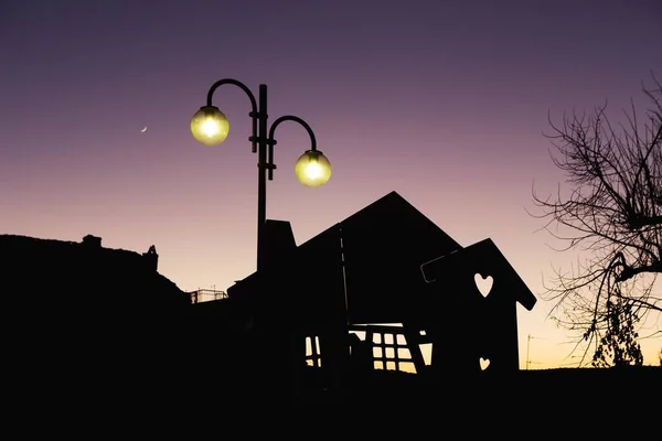 夕阳西下 天空中挂着新月形月亮 夕阳西下时 街灯旁边一座房子的轮廓 — 图库照片