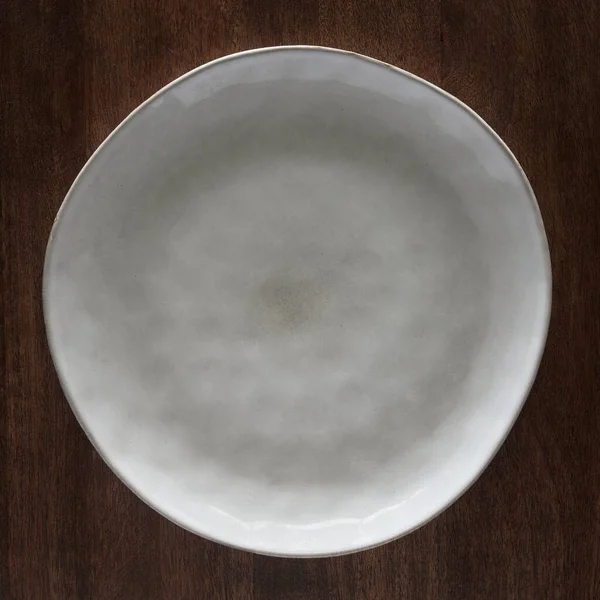 Tiro Close Uma Placa Cerâmica Branca Uma Mesa Madeira — Fotografia de Stock