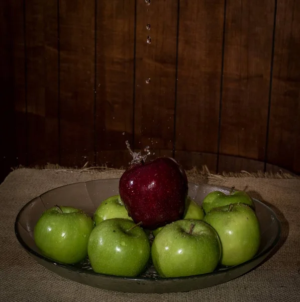 Close Maçãs Verdes Vermelhas Vaso Com Água Derramando Sobre Eles — Fotografia de Stock