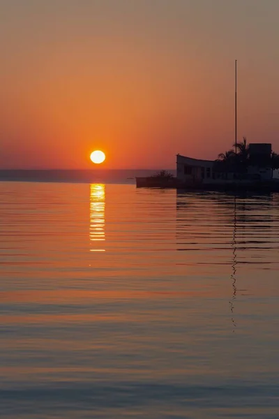 Вертикальный Снимок Спокойной Воды Закатом Солнца Горизонте — стоковое фото