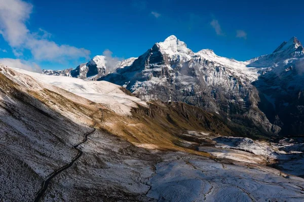 Eine Atemberaubende Aufnahme Der Schneebedeckten Felsigen Berge Unter Blauem Himmel — Stockfoto