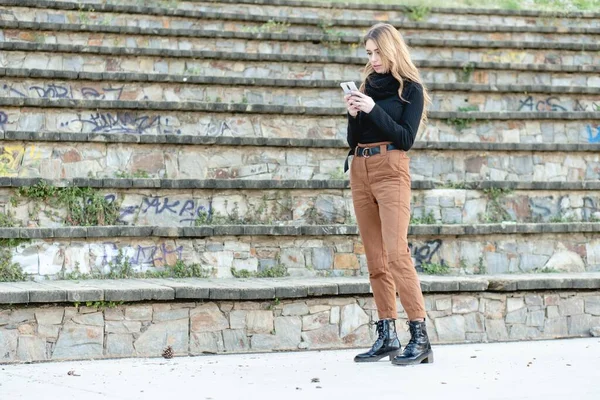 Mladá Blondýnka Černém Roláku Béžových Kalhotách Telefonu — Stock fotografie