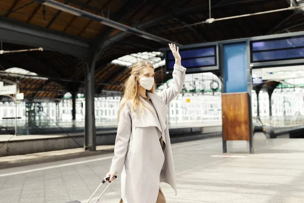 Ung Kvinna Med Resväska Ansiktsvatten Och Viftar Tågstationen Covid — Stockfoto