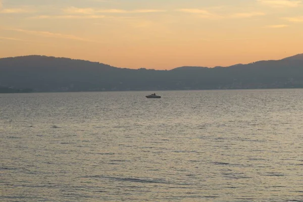 Csónak Nyugodt Tengeren Vitorlázik Melyet Hegyek Vesznek Körül Ragyogva Naplemente — Stock Fotó