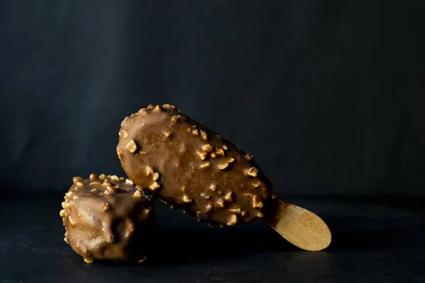Čokoládová Zmrzlina Tyčince Pokryté Lískovými Oříšky Černém Pozadí — Stock fotografie