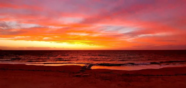 Tiro Panorâmico Uma Praia Mar Calmo Sob Céu Laranja Pôr — Fotografia de Stock