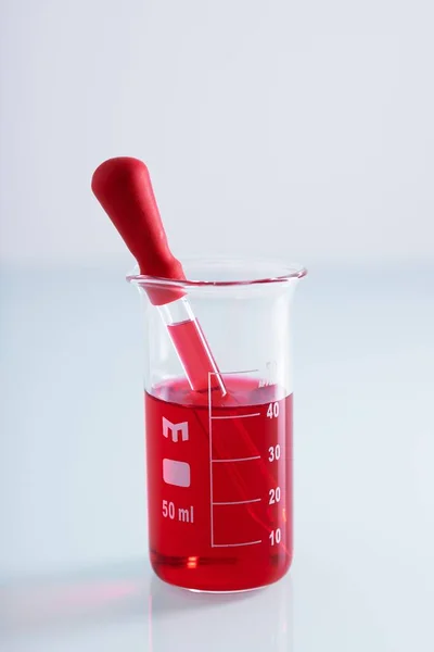 Κοντινό Πλάνο Σταγονόμετρου Ποτήρι Ζέσεως Κόκκινο Υγρό Λευκό Φόντο — Φωτογραφία Αρχείου