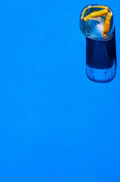 High Angle Shot Transparent Liquid Glass Orange Slices Blue Surface — Stock Photo, Image