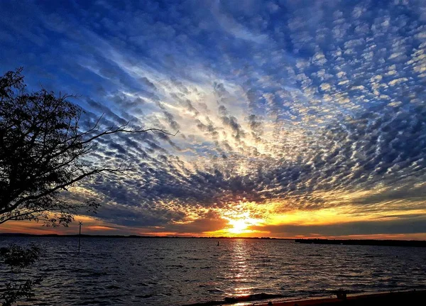 Belo Tiro Pôr Sol Céu Cheio Nuvens Sobre Água — Fotografia de Stock