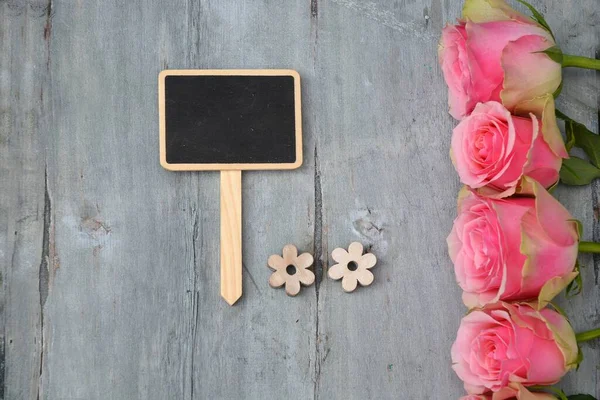 ピンクのバラの花のトップビューと木製の表面にテキストのためのスペースを持つ黒板 — ストック写真
