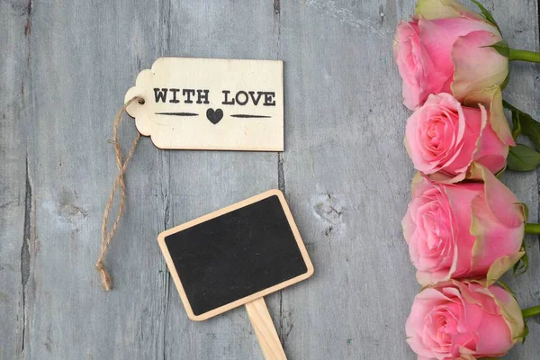 Różowe Róże Małą Drewnianą Tablicą Romantyczną Kartą Miłosną Drewnianej Powierzchni — Zdjęcie stockowe