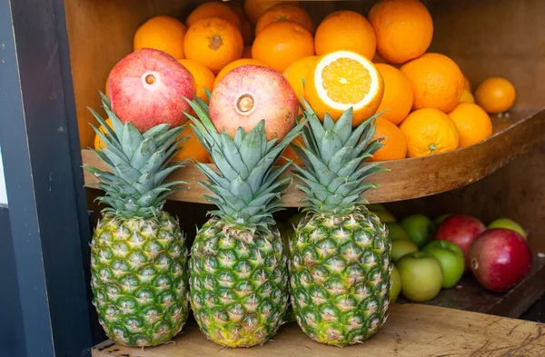 Närbild Ananas Ett Bord Med Apelsiner Och Granatäpplen Bakgrunden — Stockfoto