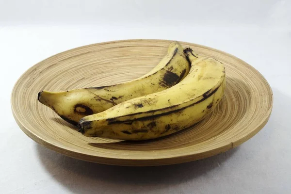Два Спелых Банана Служили Деревянной Тарелке Изолированной Белом Фоне — стоковое фото