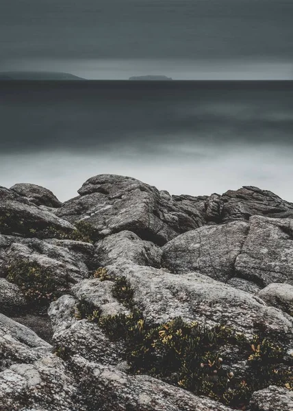 안개낀 해변의 아름다운 바위들을 수직으로 — 스톡 사진