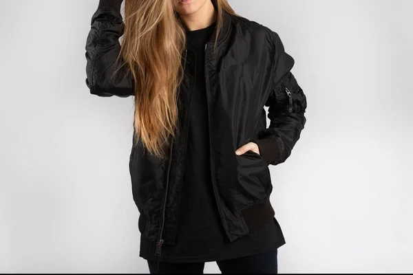 Uma Jovem Mulher Usando Uma Jaqueta Preta Contra Uma Parede — Fotografia de Stock