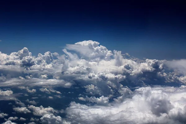 飛行機の窓から見る深い青い空と雲の景色 — ストック写真