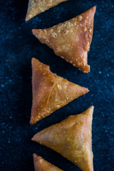 Tiro Vertical Samosa Alinhada Com Fundo Azul Escuro — Fotografia de Stock