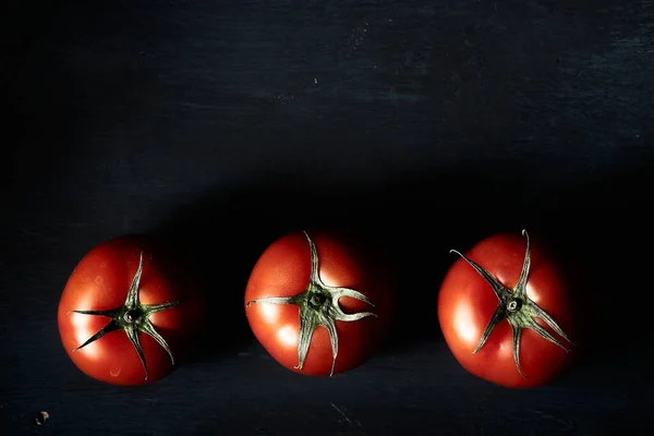 Eine Hochwinkel Nahaufnahme Von Drei Frischen Tomaten Auf Schwarzem Hintergrund — Stockfoto