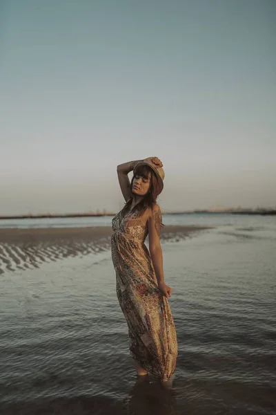 青い海の背景にドレスと藁帽子を身に着けている入れ墨を持つ若い女性 — ストック写真