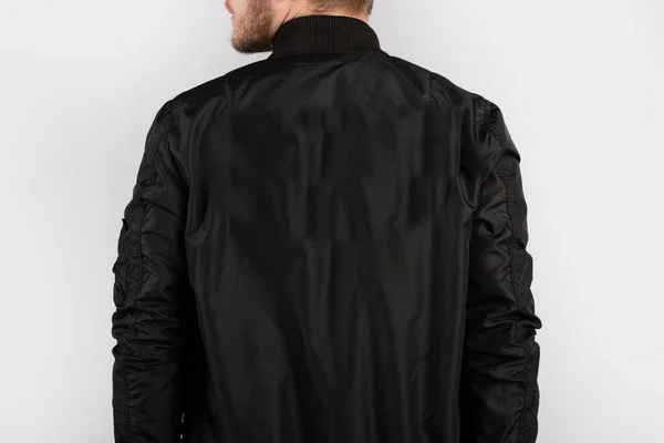 Egy Fiatal Fekete Kabátot Visel Fehér Falnak Támaszkodva — Stock Fotó