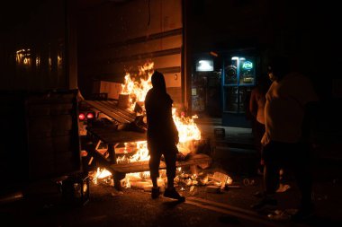 ALBANY, NEW YORK, UNITED STATES - May 30, 2020: Protesters light fires on a street during a riot and looting following the death of George Floyd in Albany, New York clipart